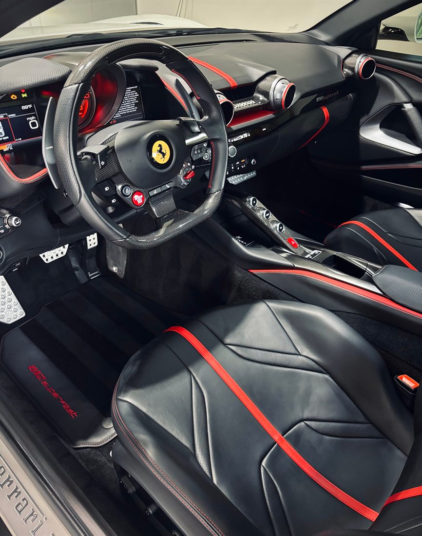 The black-and-red leather cabin of a Ferrari 812 Superfast, detailed.
