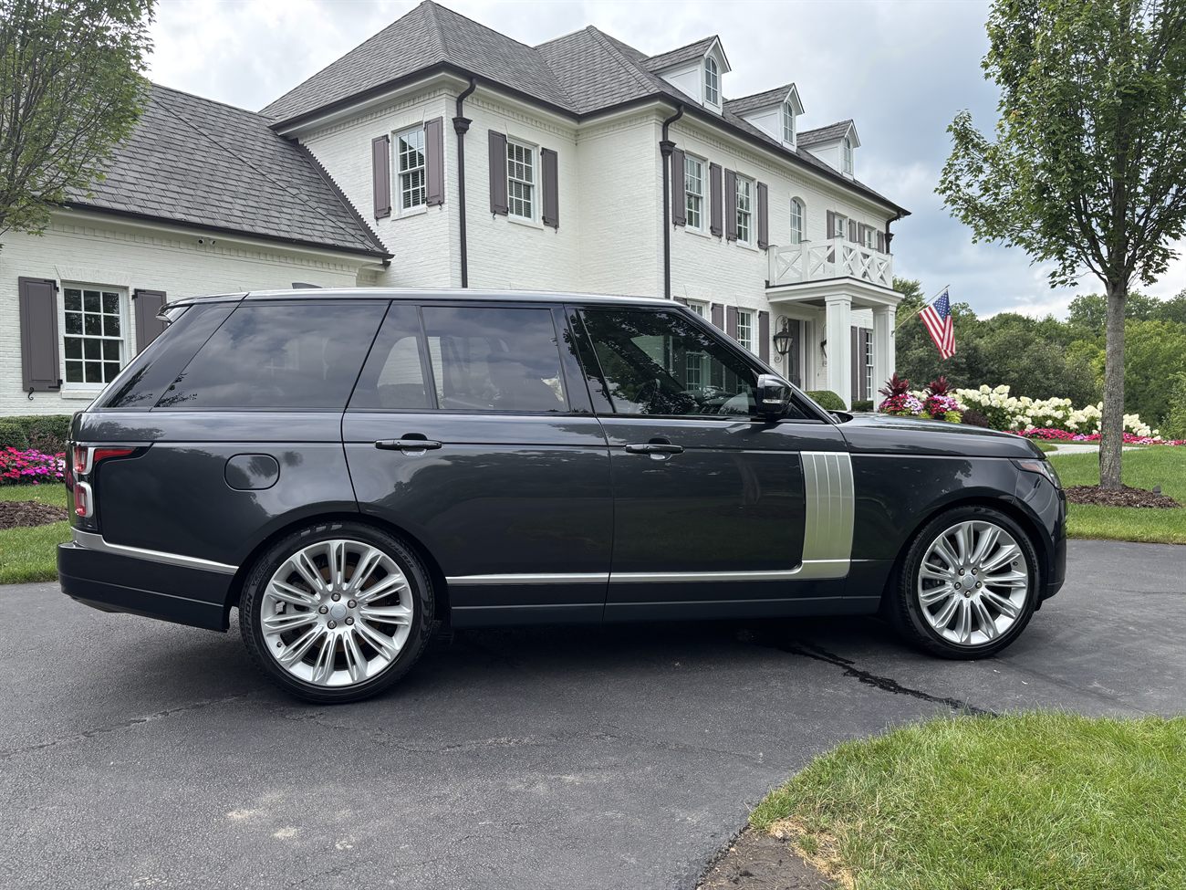 A graphite Range Rover Autobiography detailed in front of an estate.